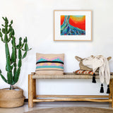 boho living room with a wooden bench, colorful pillows, a san pedro cactus plant, and a framed Studio Skye Silver giclee fine art print of her psychedelic tree roots painting, the all knowing